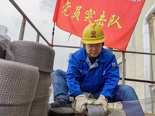 5月10日中午，在動(dòng)力車間三期工藝除氧器平臺(tái)上，黨員突擊隊(duì)隊(duì)長李鑫正在纏繞新填料.jpg