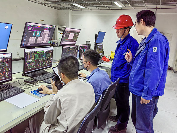 5月13日，動(dòng)力車(chē)間三期鍋爐控制室，DCS改造工藝、儀表、電氣等部門(mén)聯(lián)合調(diào)試，車(chē)間主任姜軍虎與技術(shù)員畢加佳查看調(diào)試過(guò)程.jpg