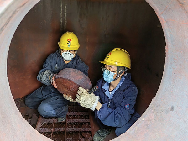 5月11日，動力車間三期工藝除氧器內(nèi)部，黨員突擊隊隊員劉瑞斌和李震正在清理舊填料.jpg