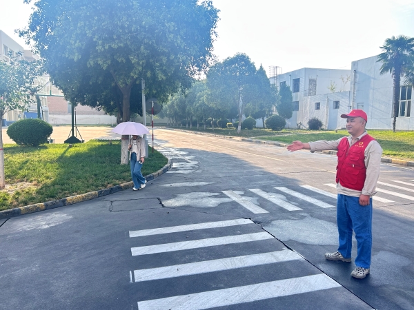 151755218508642294.jpg 廠區(qū)南門路口,引導(dǎo)員積極引導(dǎo)大家按標(biāo)線行駛.jpg